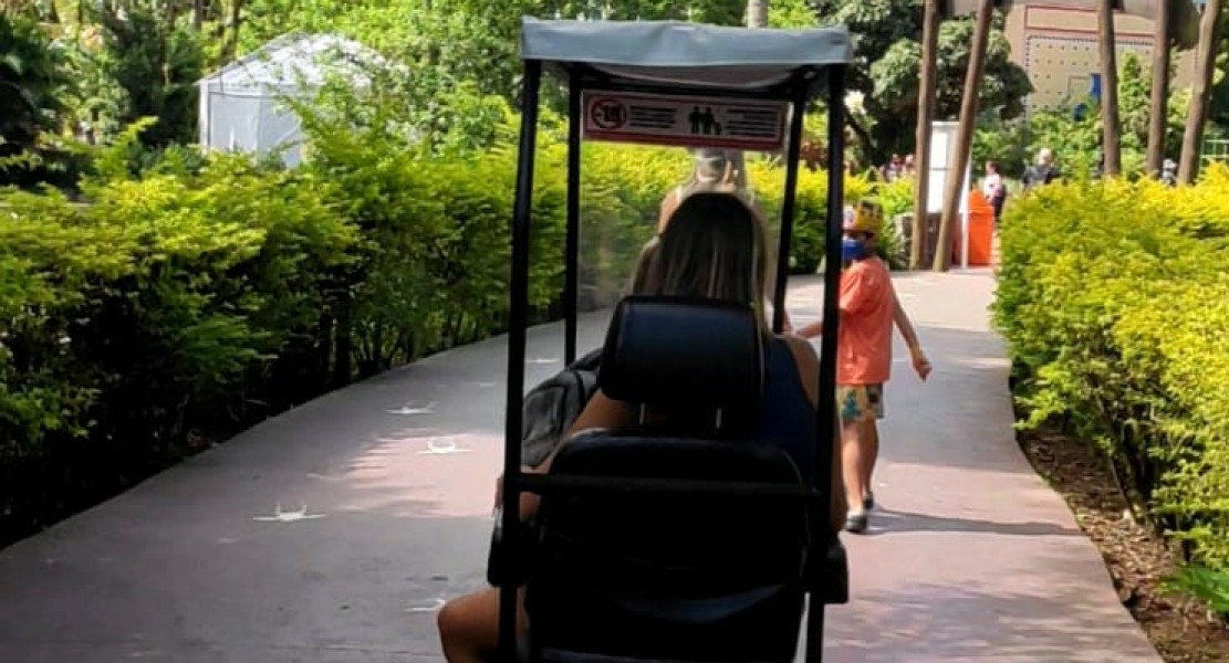 Maria do Sol circulando em parque temático graças aos equipamentos para mobilidade reduzida